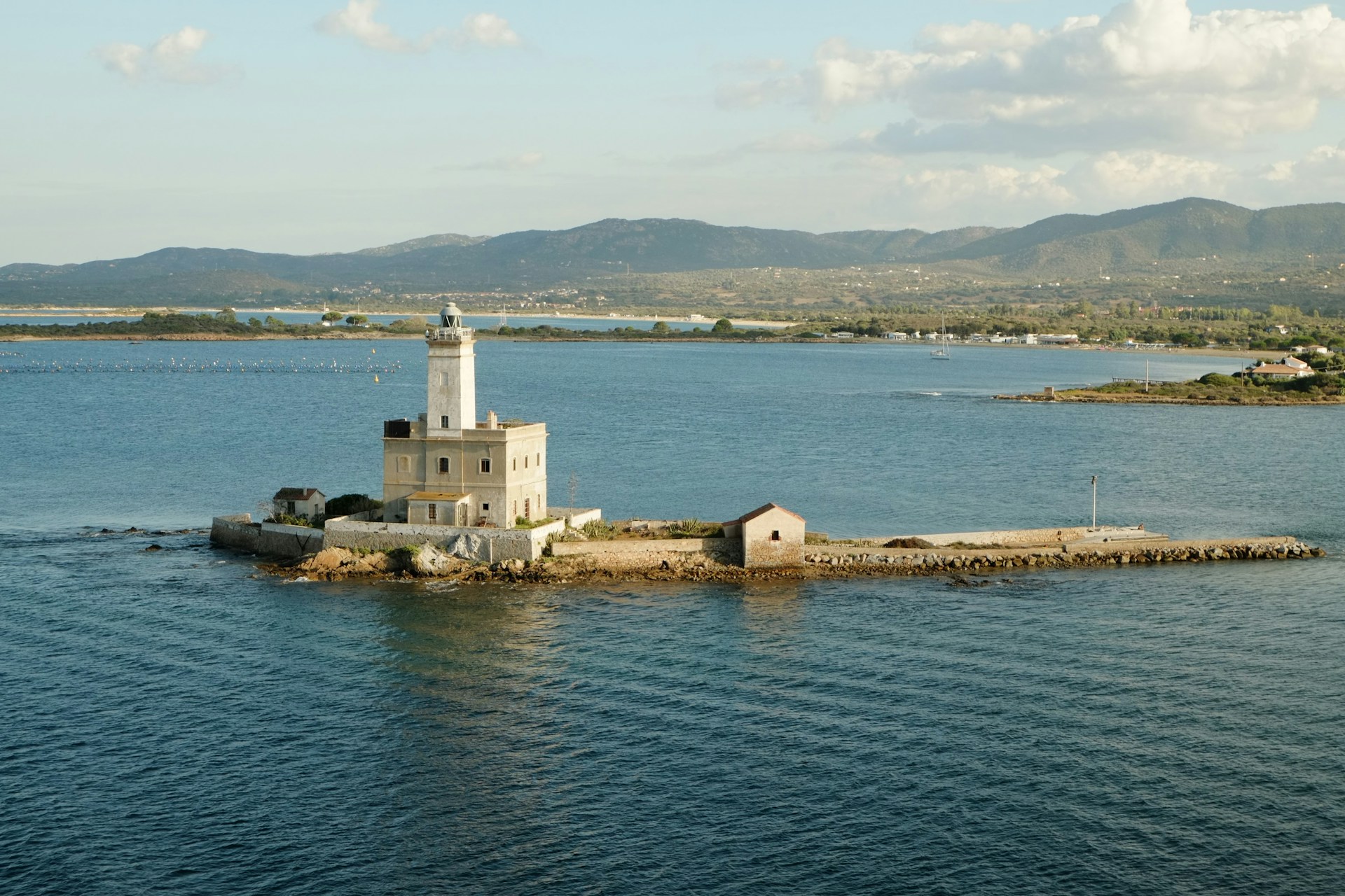 A lighthouse on a small island in the middle of the ocean