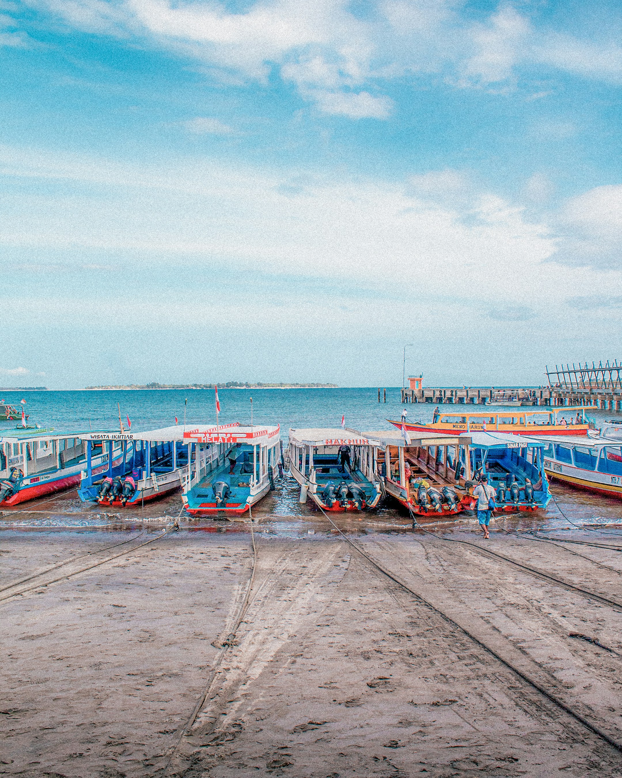 A group of boats sitting on top of a sandy beach
