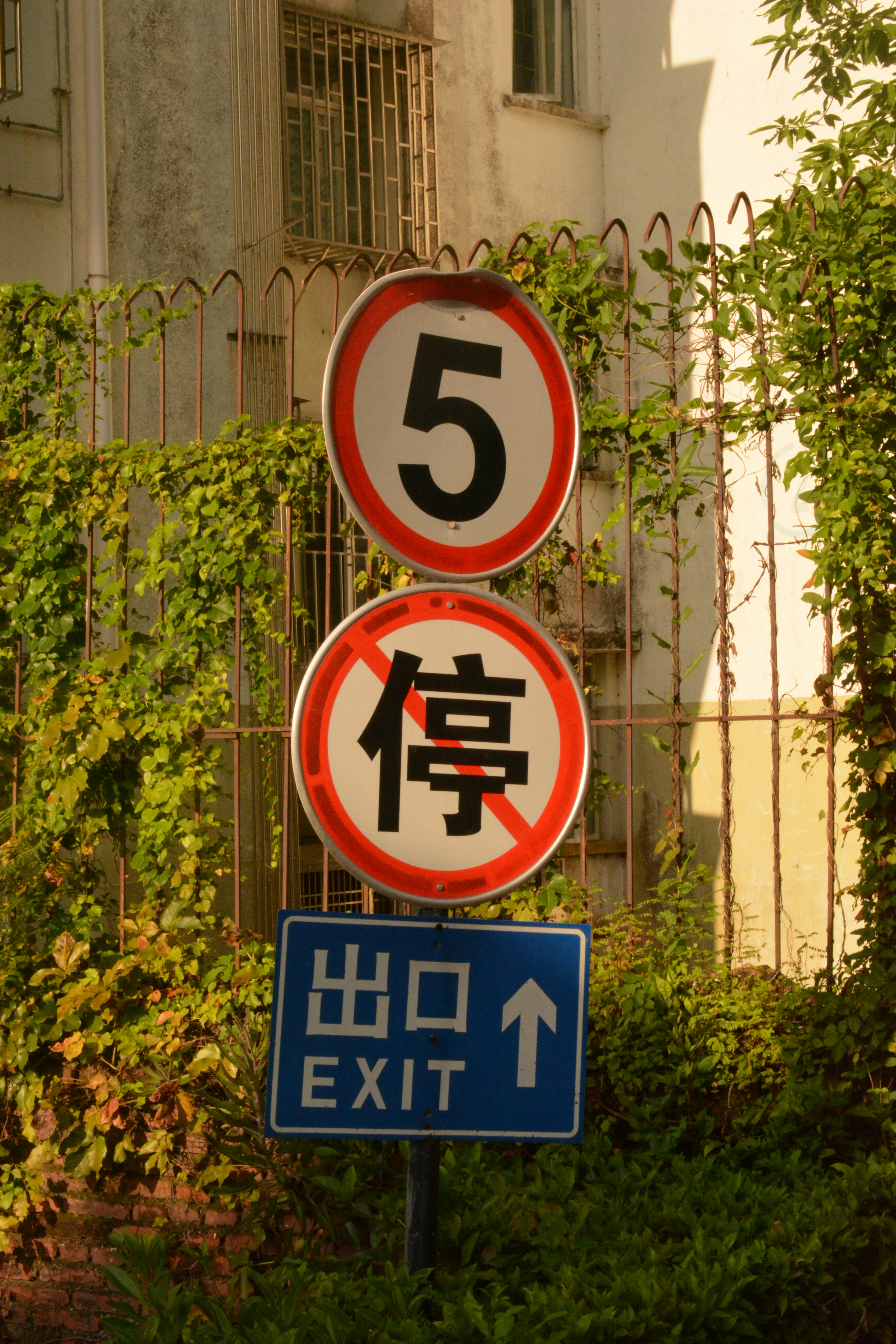 A street sign in a foreign language next to a building