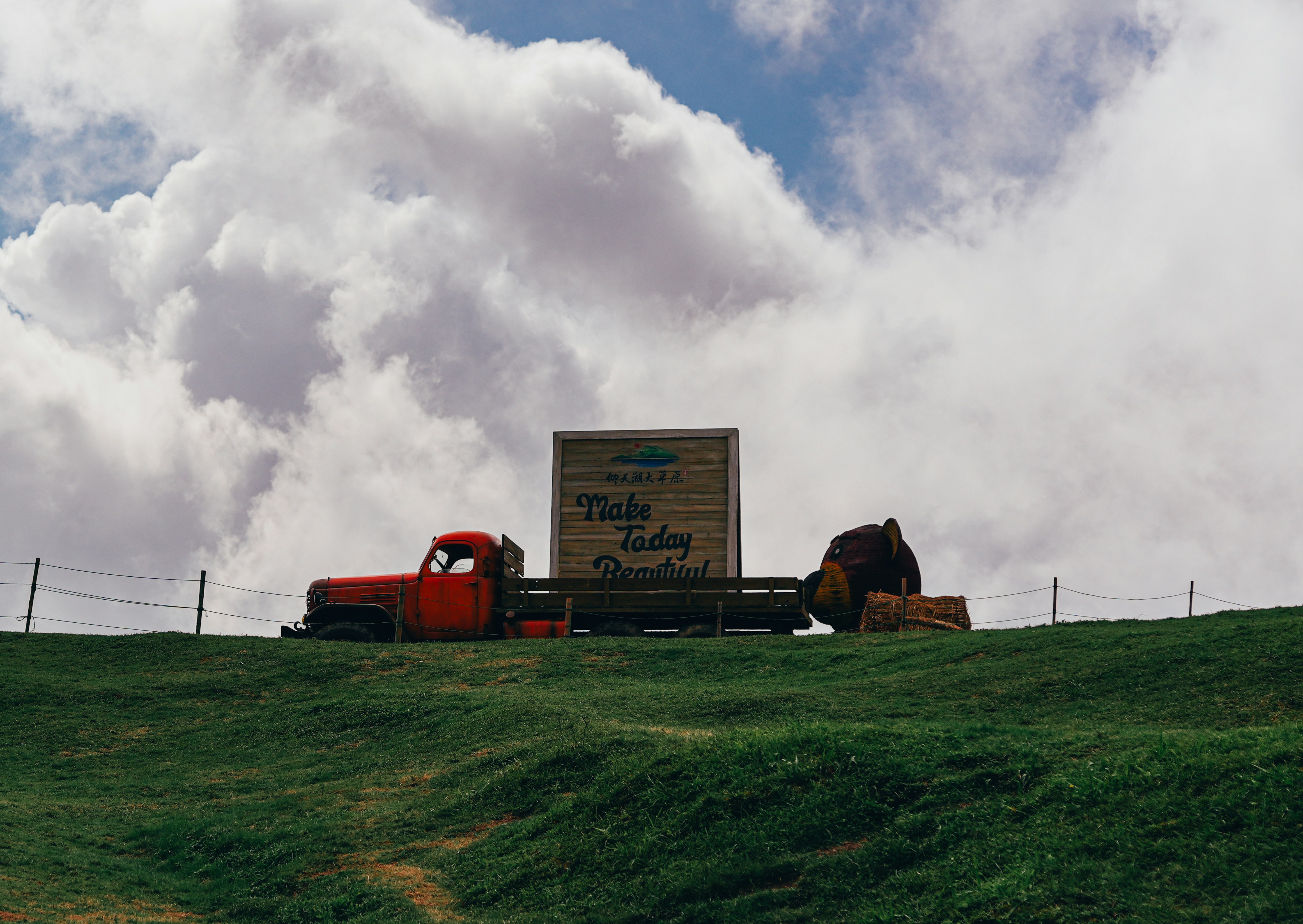 Un camion rosso che scende lungo una lussureggiante collina verde