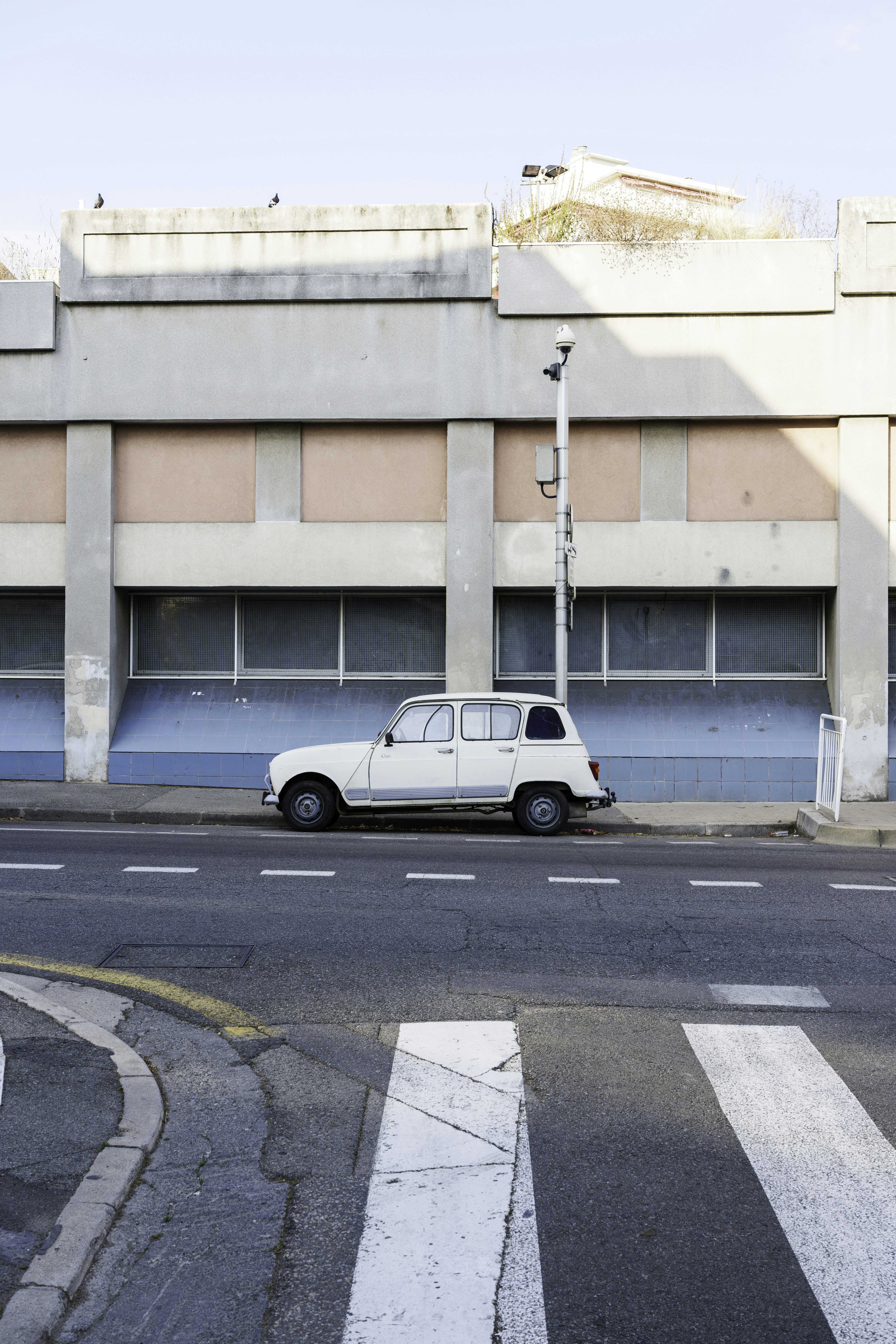 Un pequeño coche blanco aparcado frente a un edificio