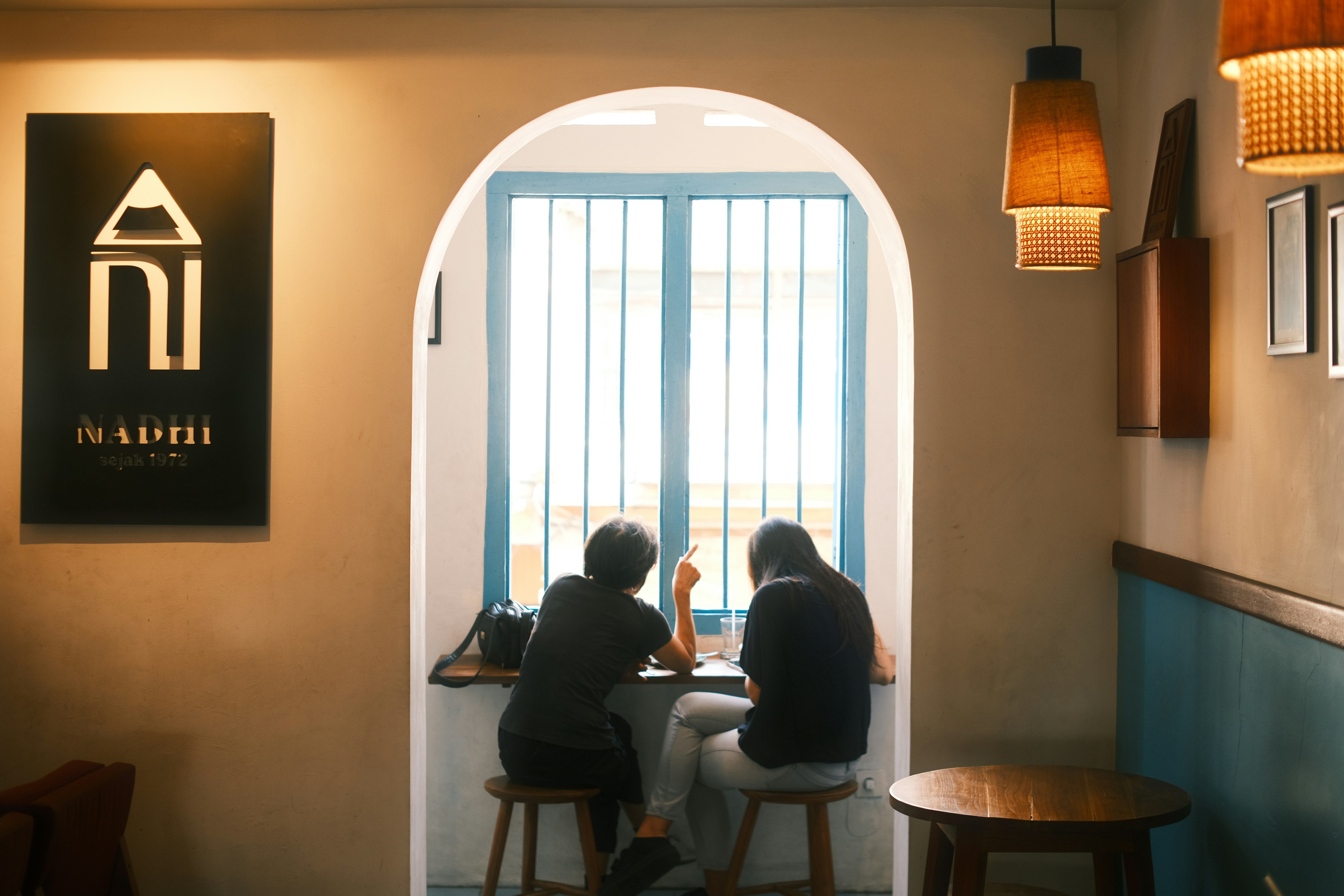 Two people sitting at a table in front of a window