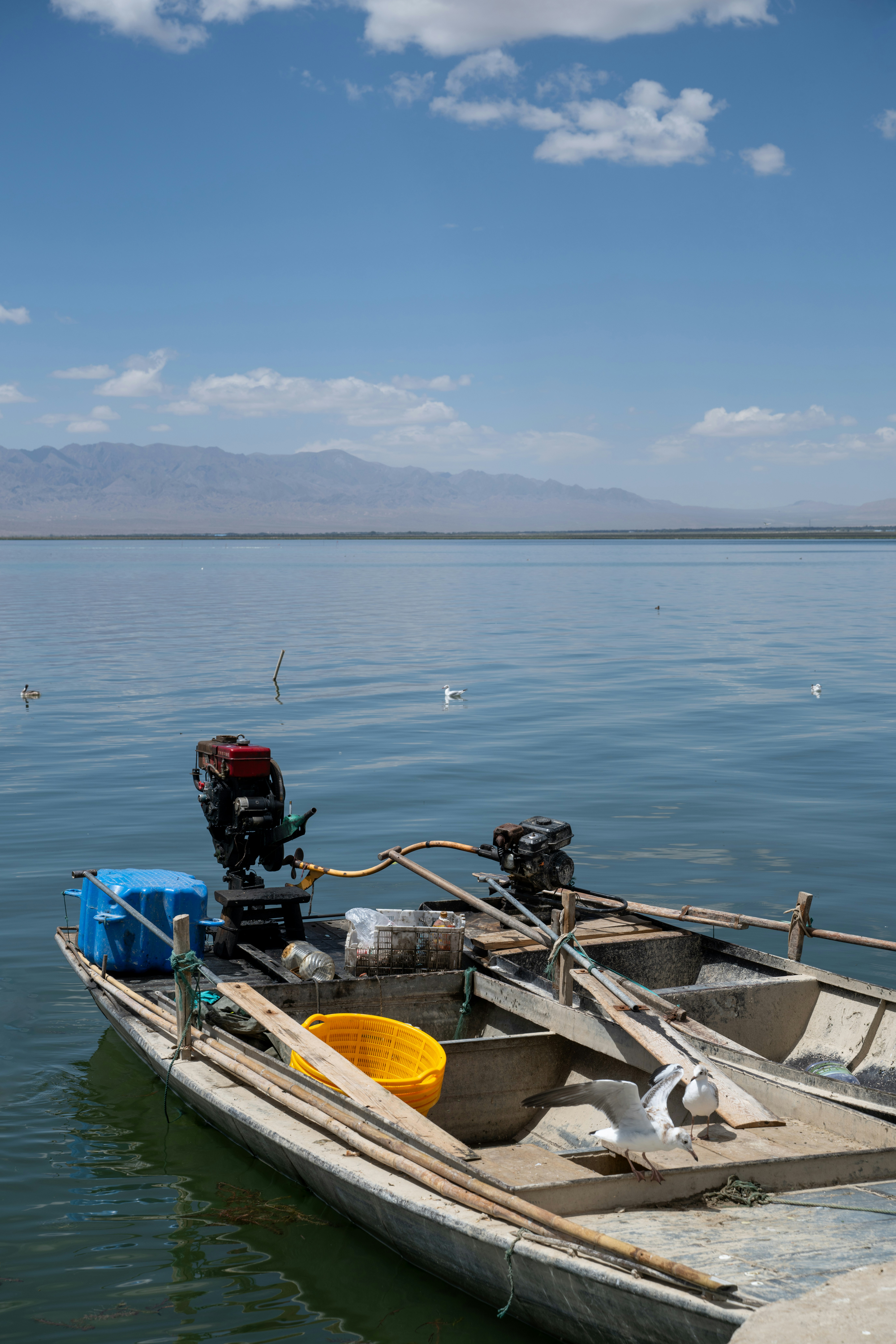 A small boat floating on top of a large body of water