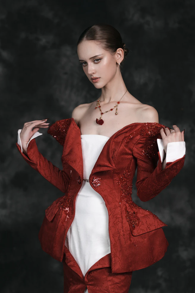 A woman in a red jacket and white dress