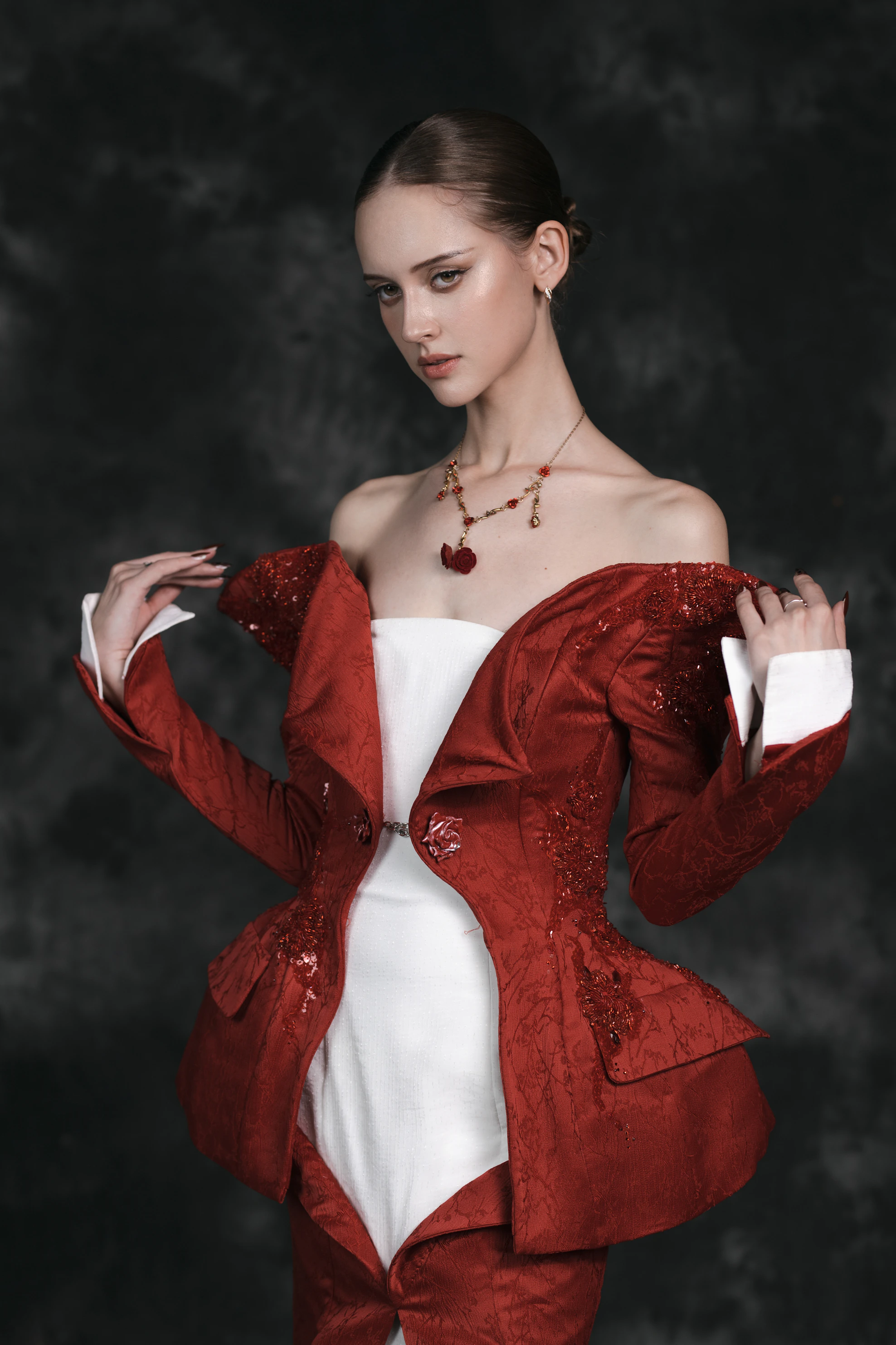 A woman in a red jacket and white dress