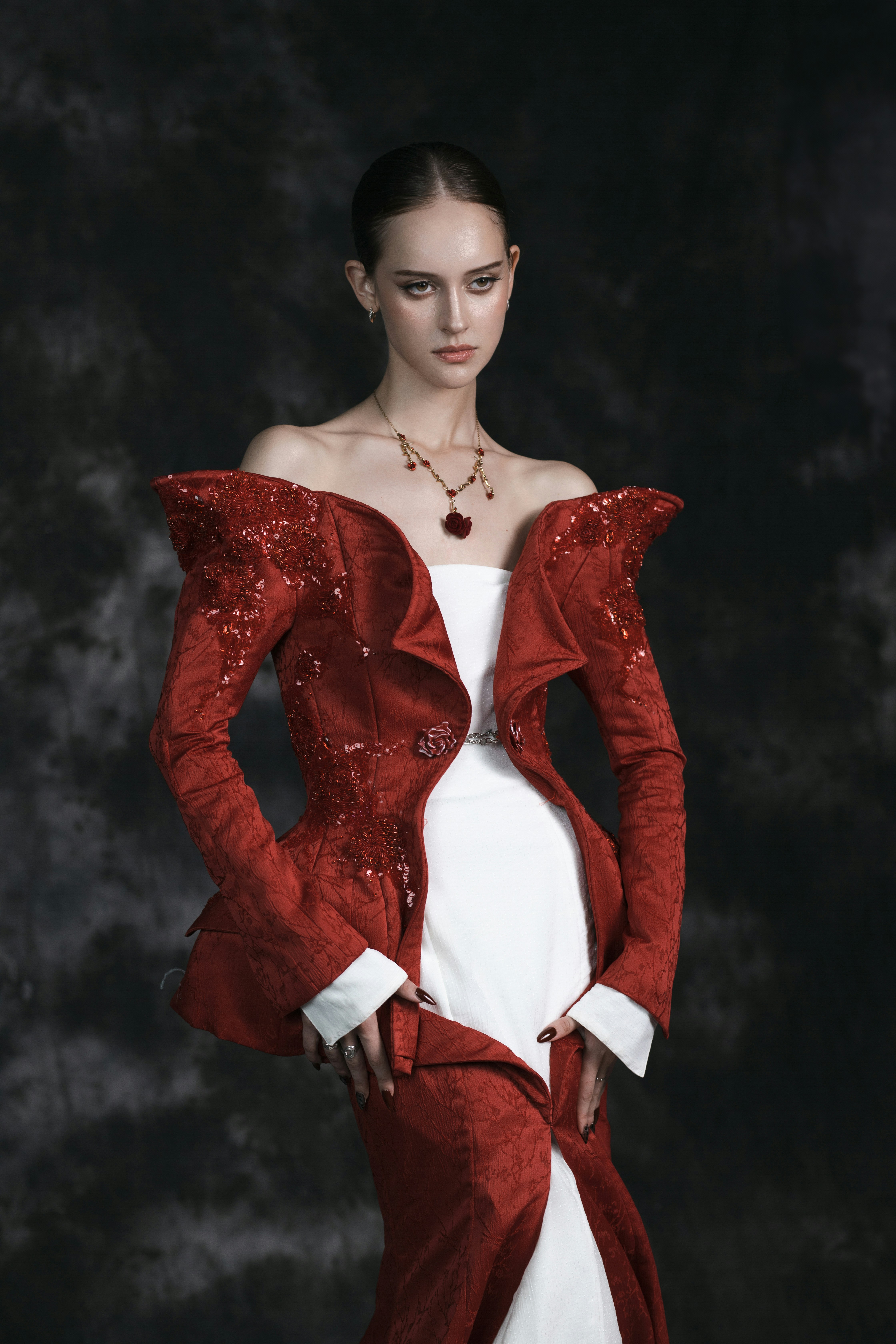Uma mulher em um revestimento vermelho e em um vestido branco