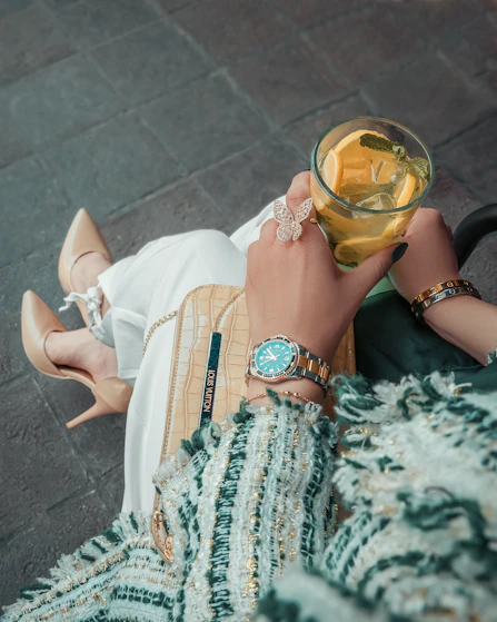 A woman laying on the ground holding a glass of wine