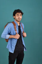 A man standing with a backpack on his shoulder