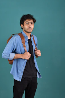 A man standing with a backpack on his shoulder