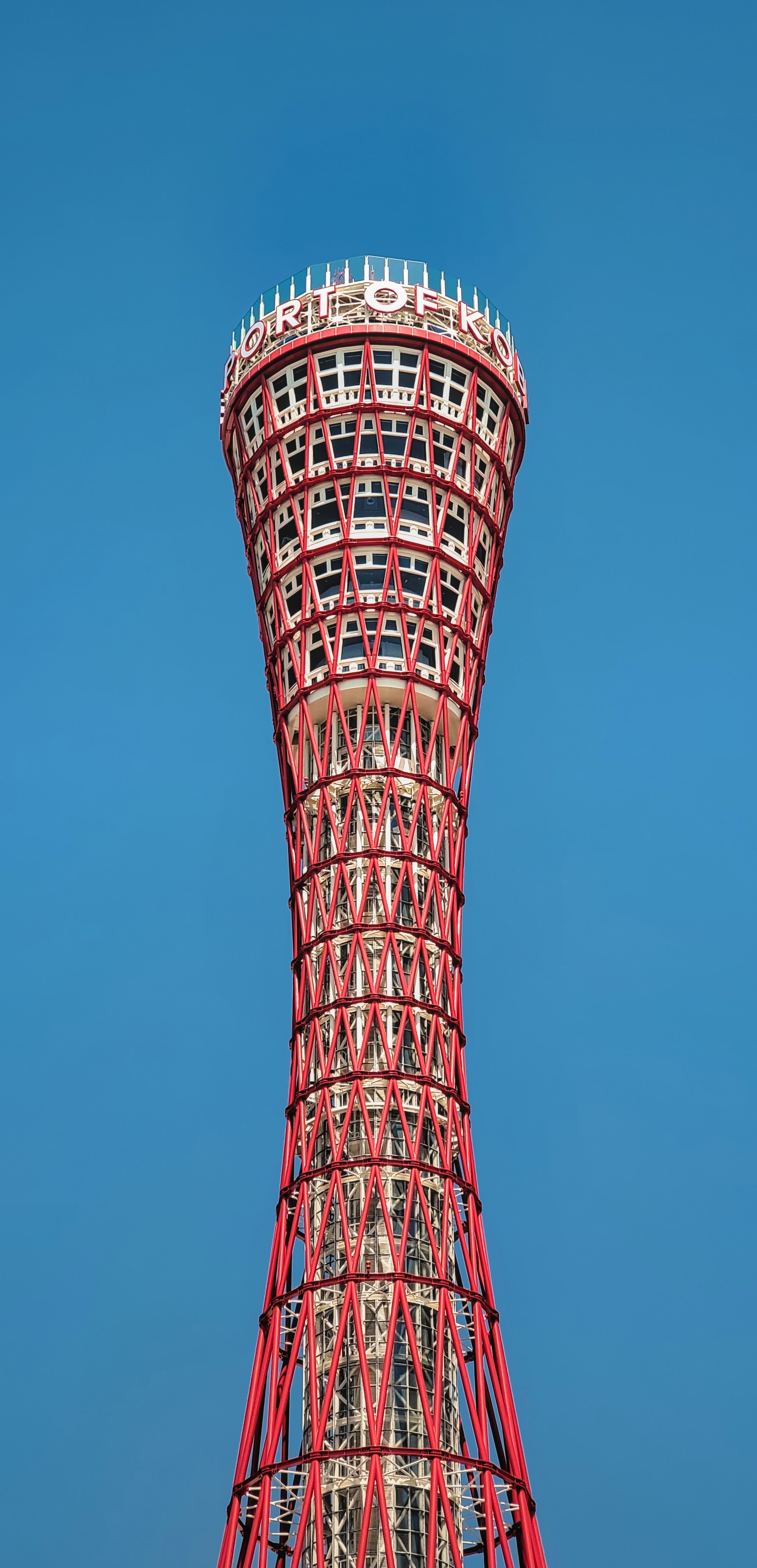 A tall red tower sitting on top of a lush green field