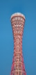 A tall red tower sitting on top of a lush green field