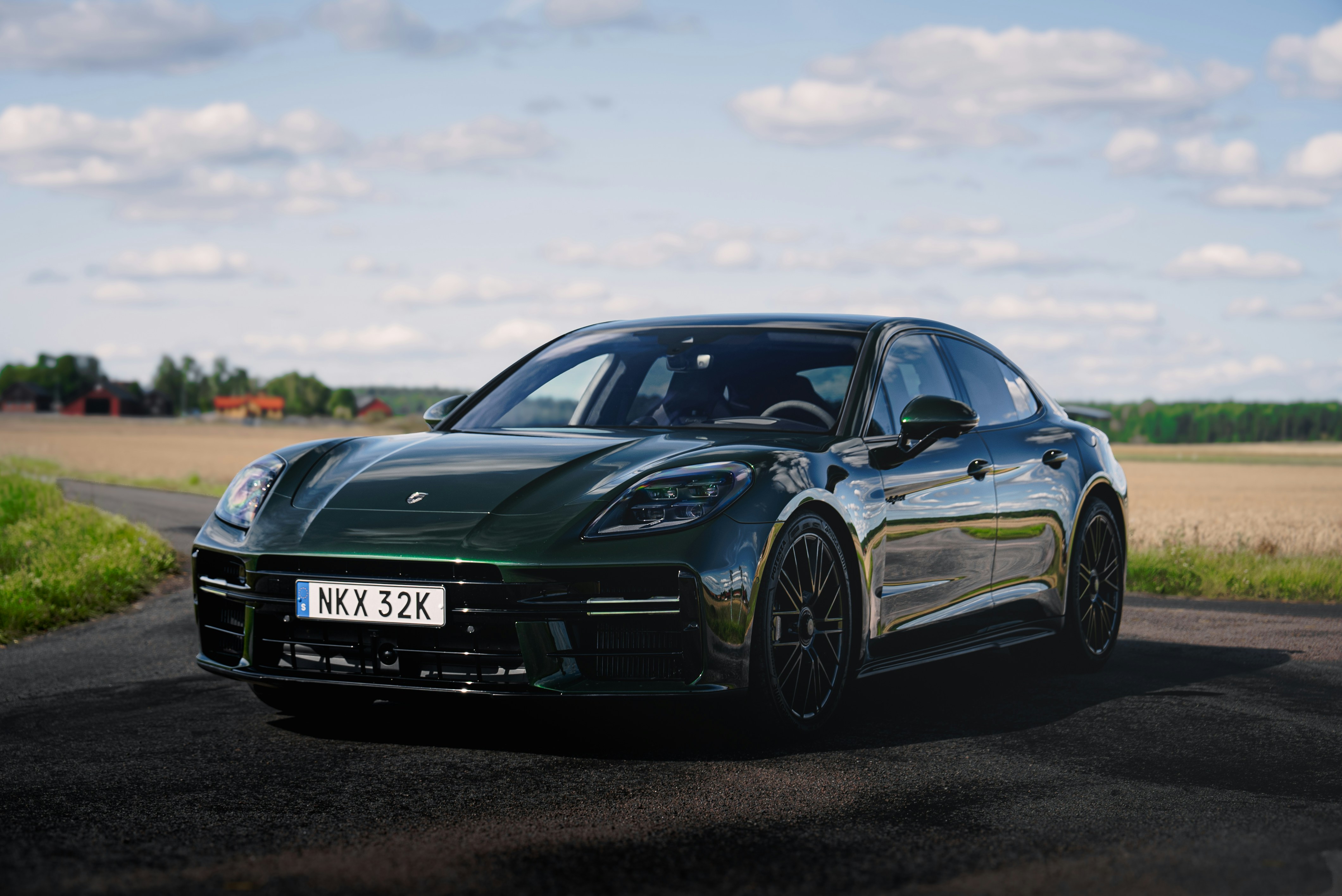 A black sports car driving down a country road