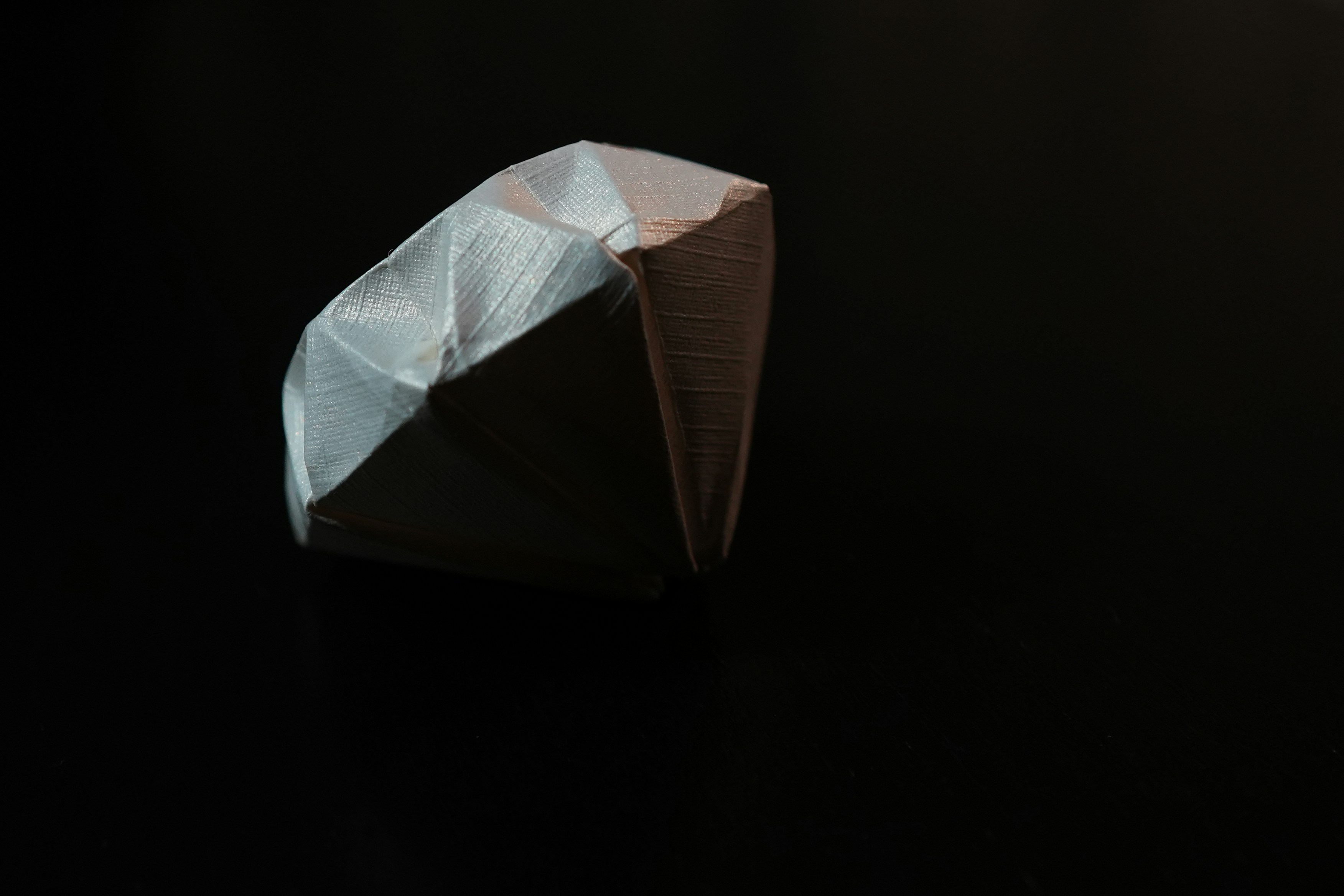 An origami piece of paper on a black surface