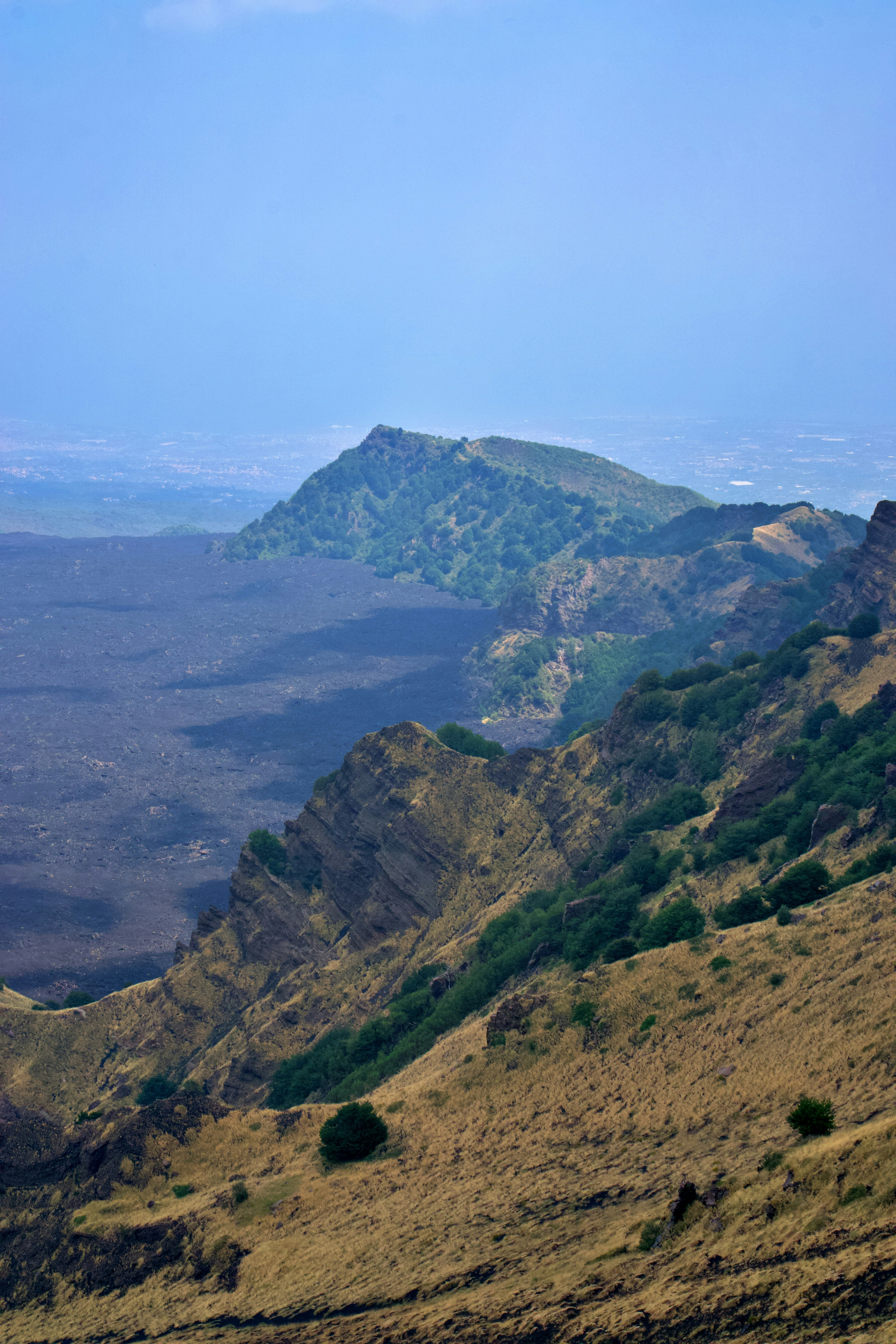 A view of a mountain range from the top of a hill