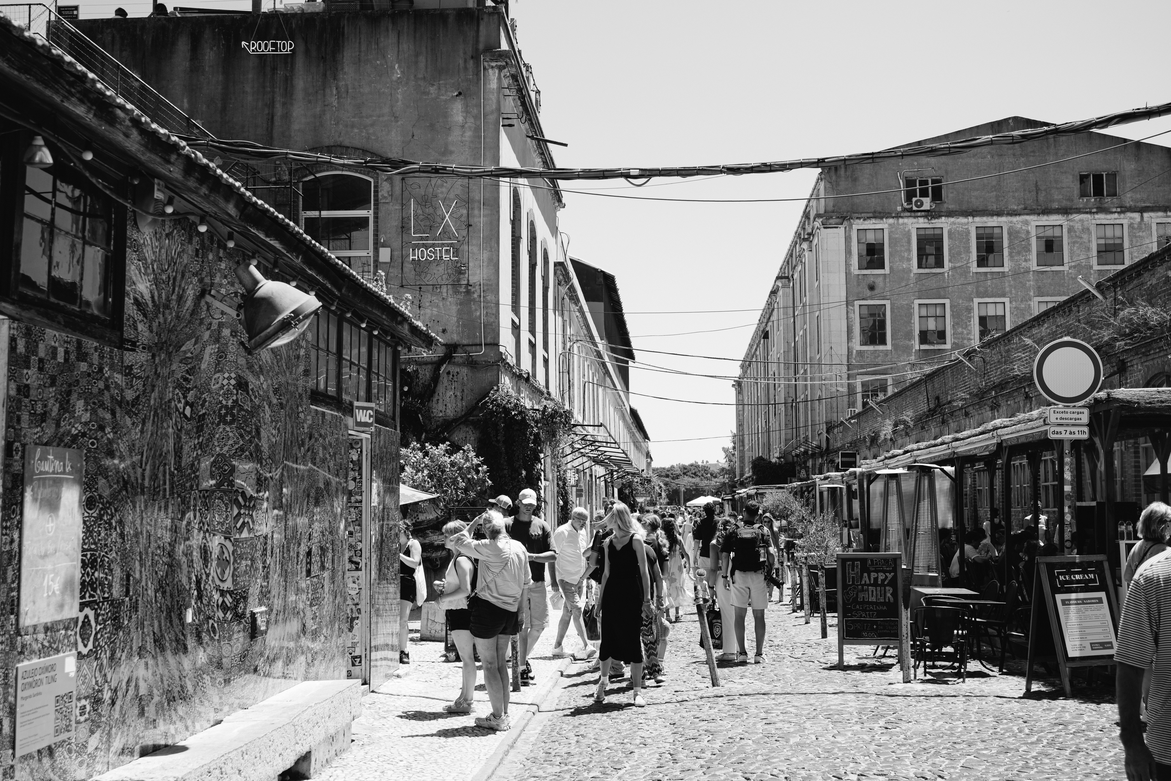 A black and white photo of people walking down a street