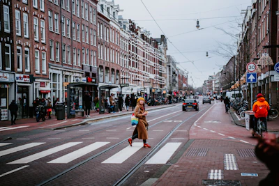 A woman crossing the street in a city