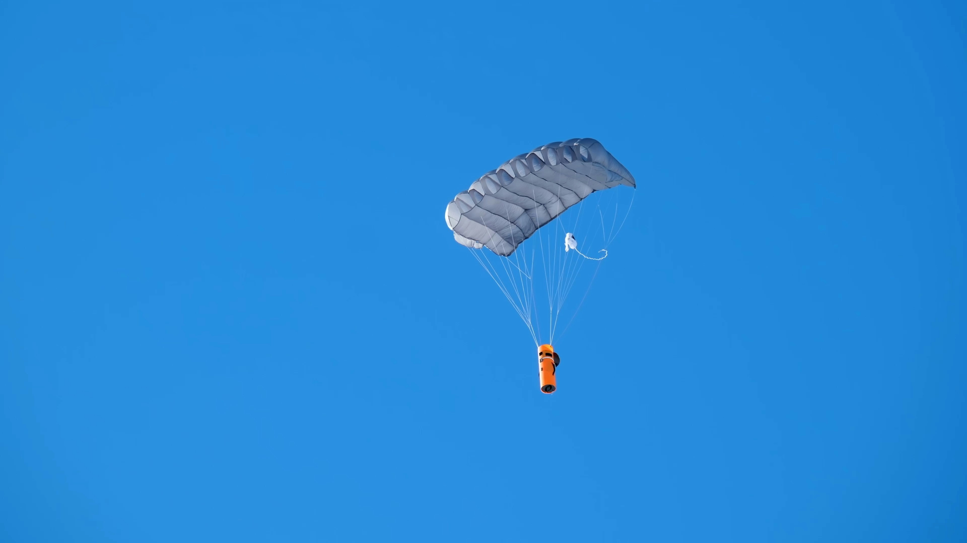 A parasailer is flying through the blue sky
