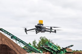A large pile of dirt next to a green machine