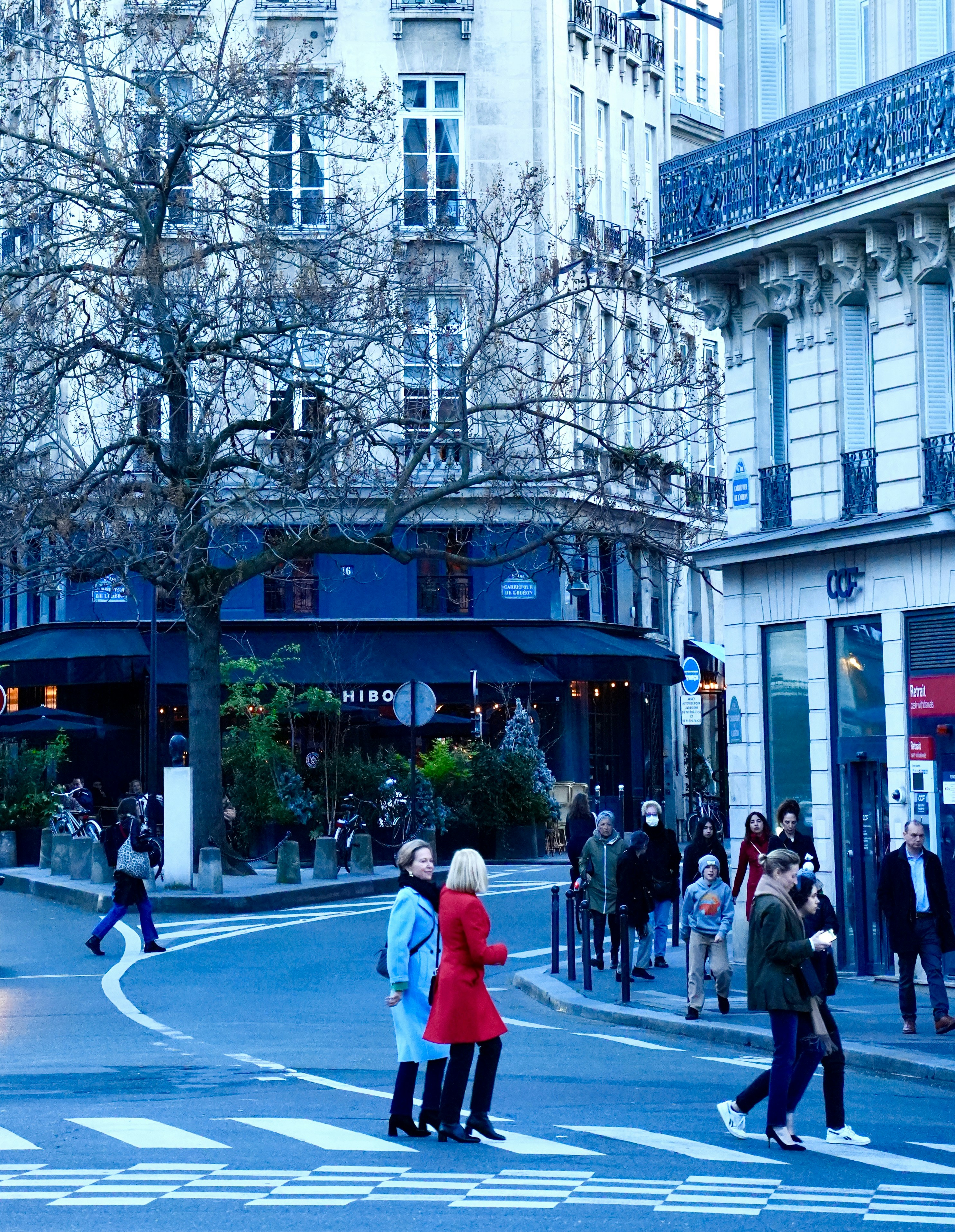 A group of people crossing a street at a crosswalk