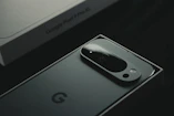 A close up of a cell phone near a laptop