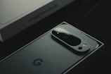 A close up of a cell phone near a laptop