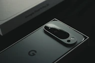 A close up of a cell phone near a laptop