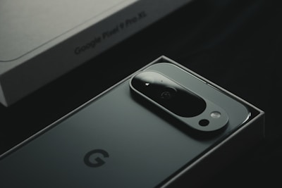A close up of a cell phone near a laptop