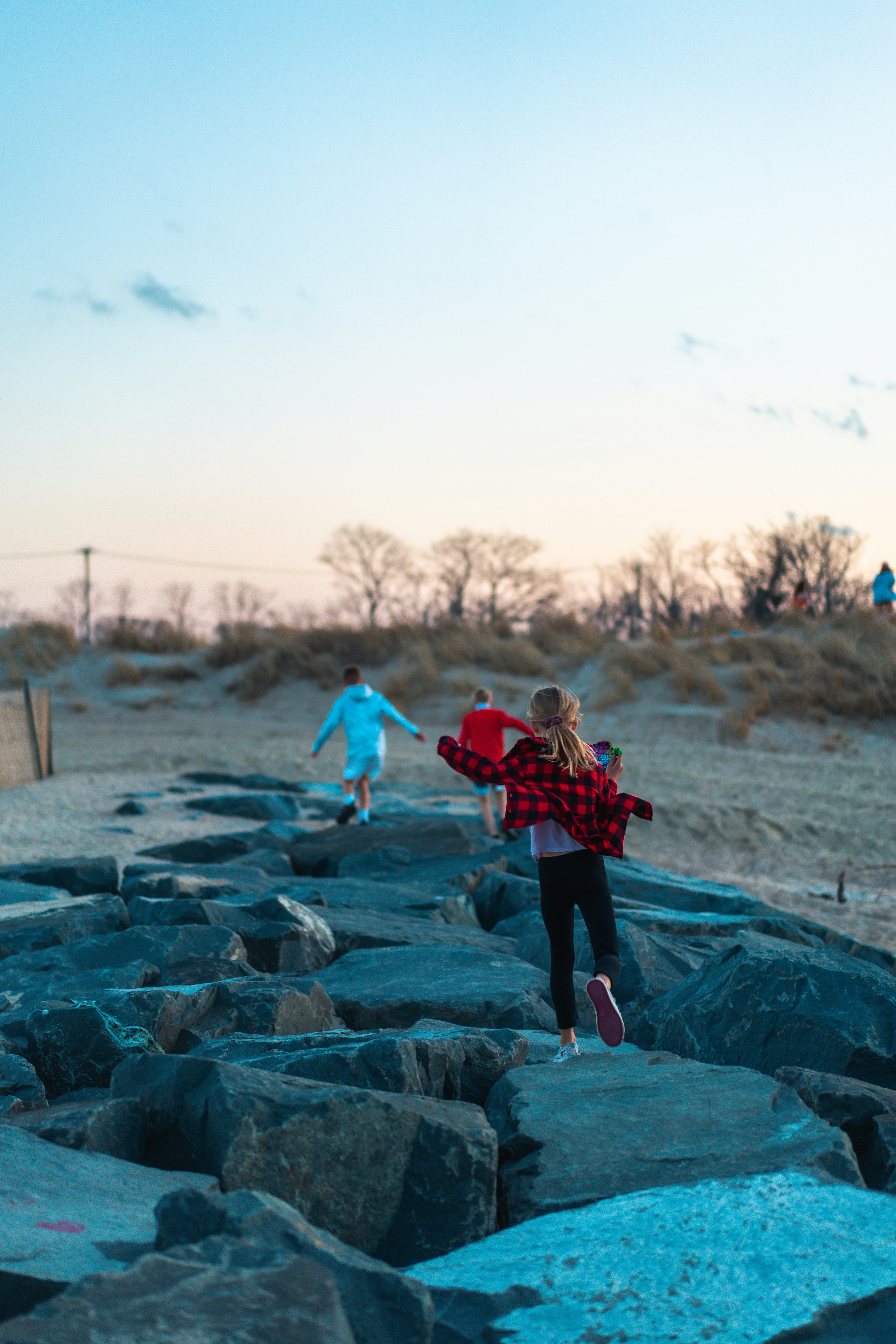 A group of people standing on top of a rocky beach