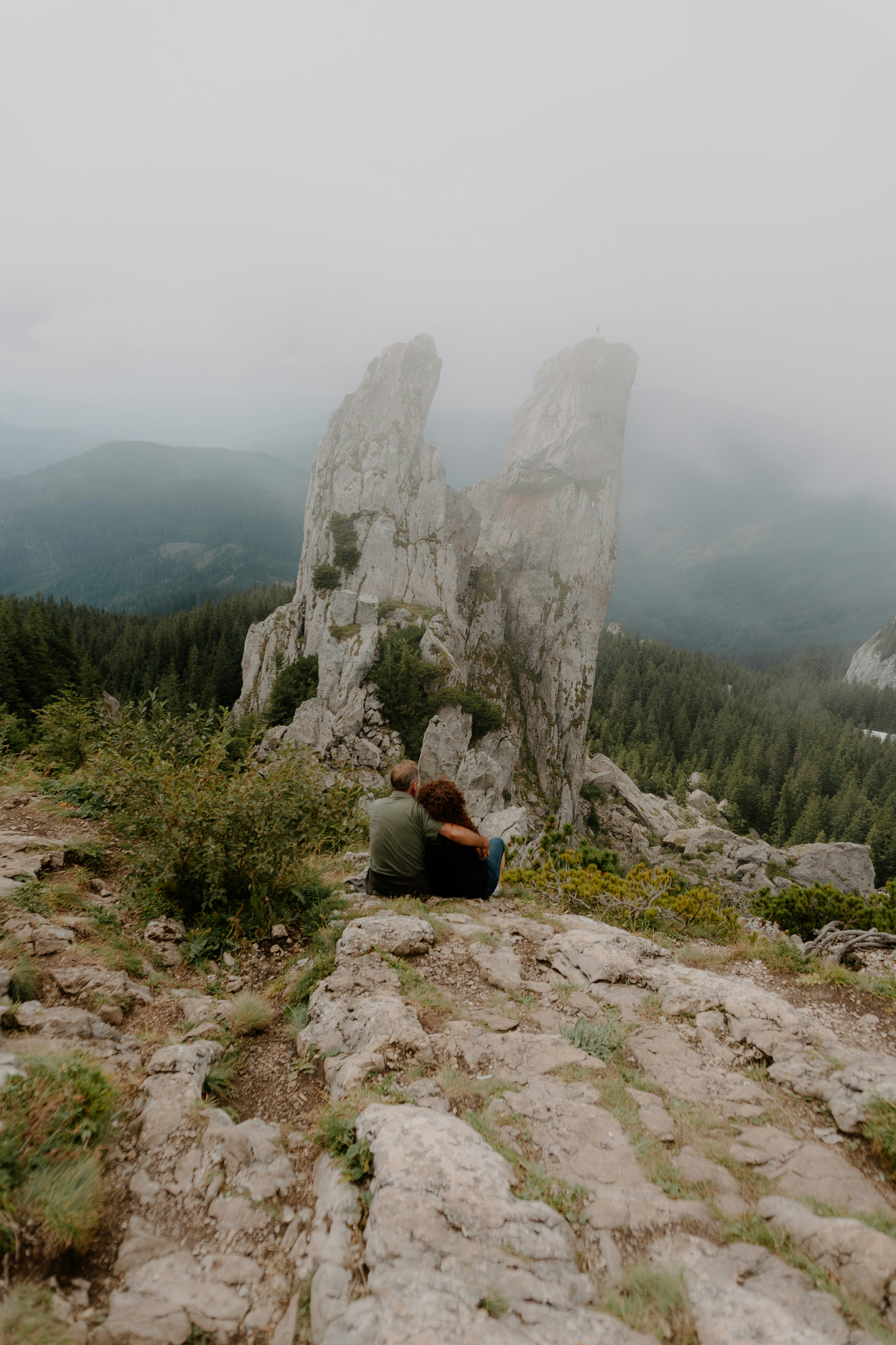 A person sitting on top of a rocky hill