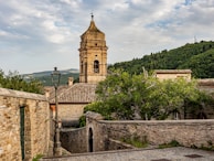 A stone building with a clock tower in the background