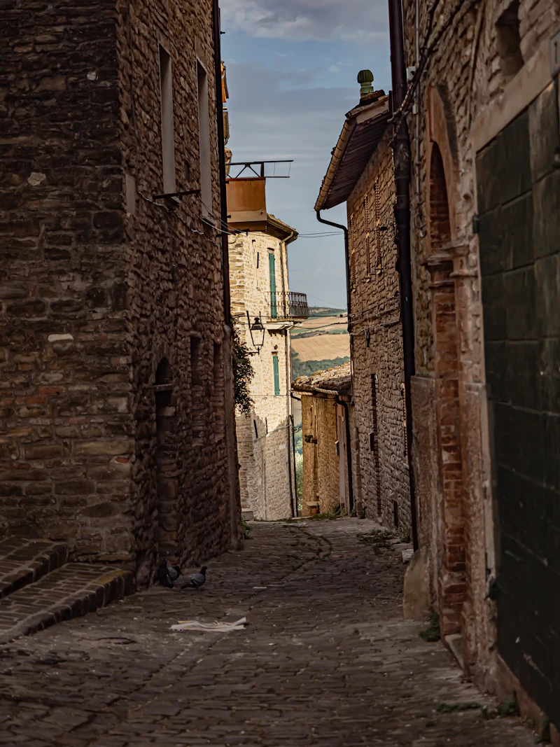 Vicolo di un borgo marchigiano in provincia di Ancona con torre dell’orologio