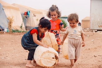 A group of children playing with a large drum