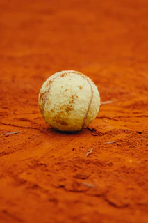 A tennis ball sitting on a tennis court