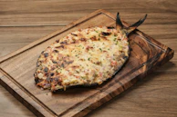 A pizza sitting on top of a wooden cutting board