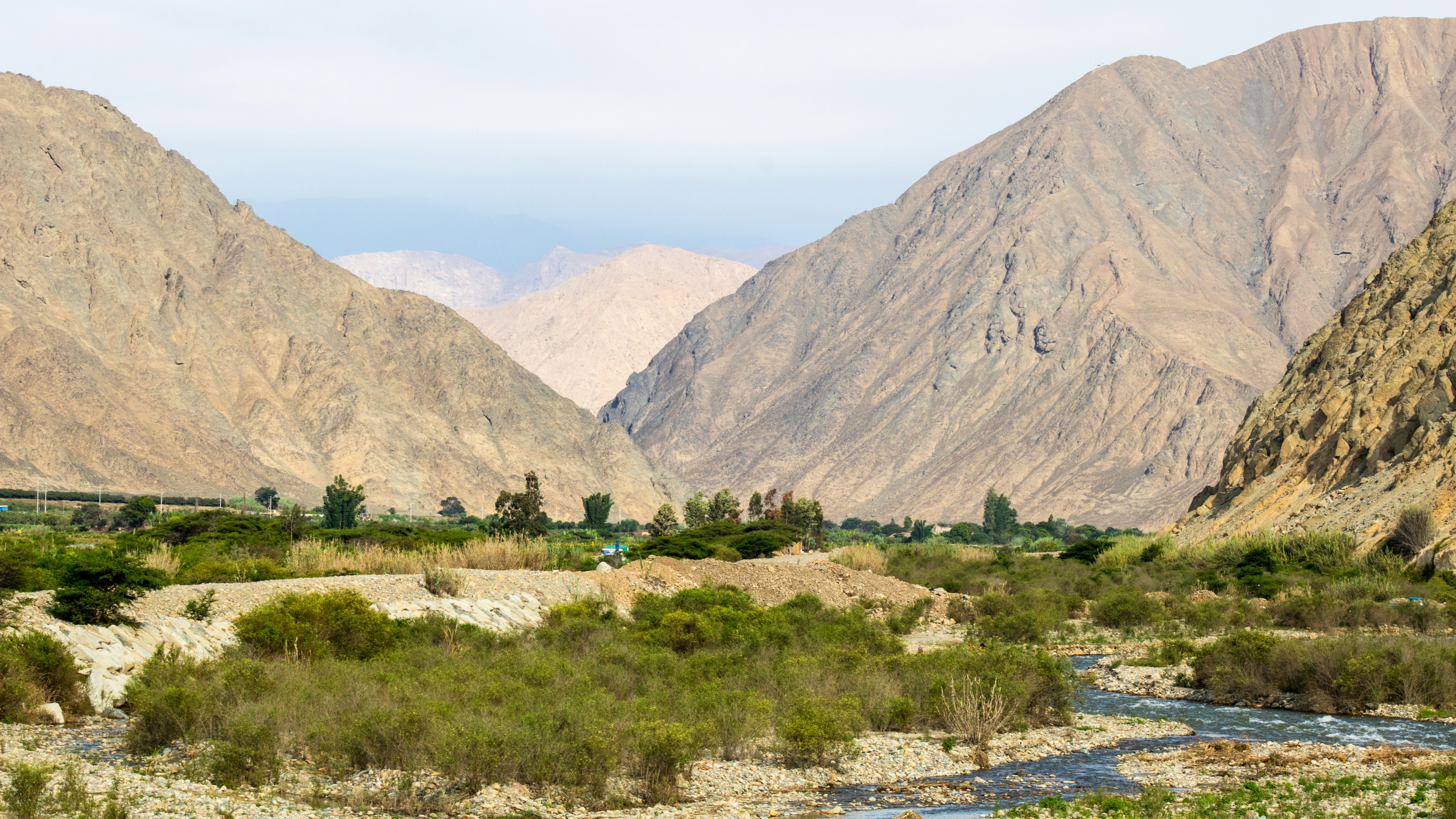 A river running through a lush green valley, 