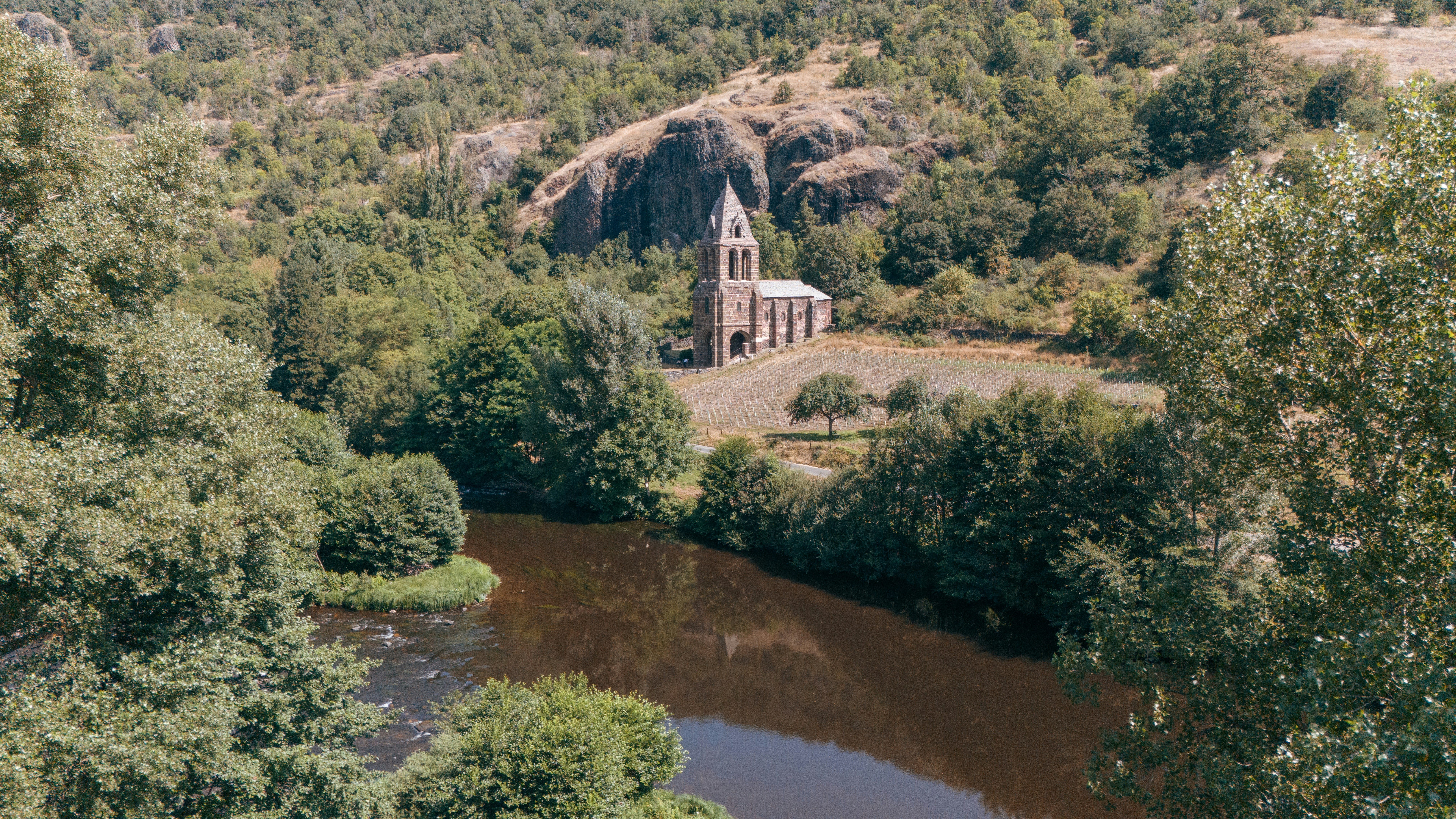 An aerial view of a church surrounded by trees