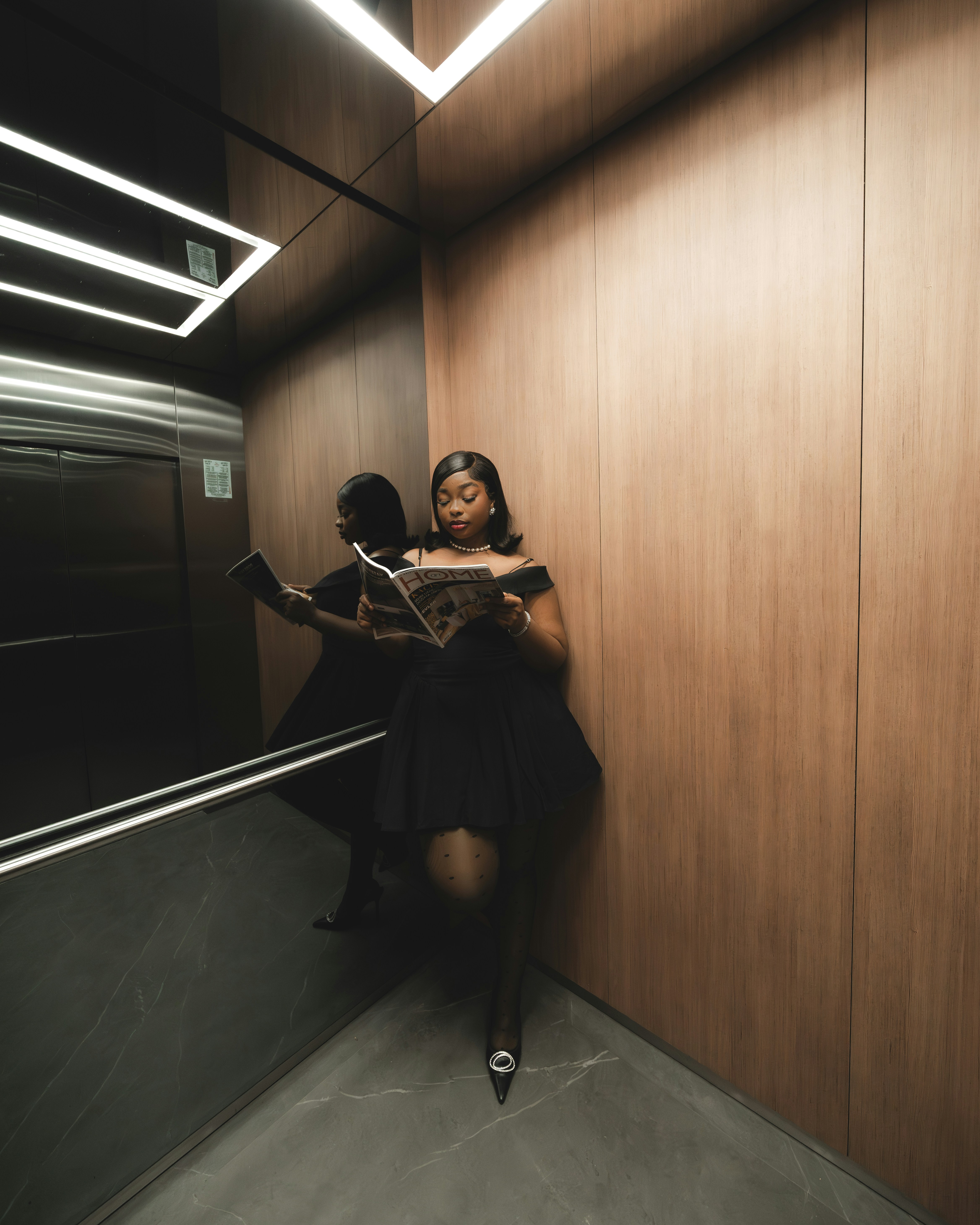 Two people sitting on a wall reading a book