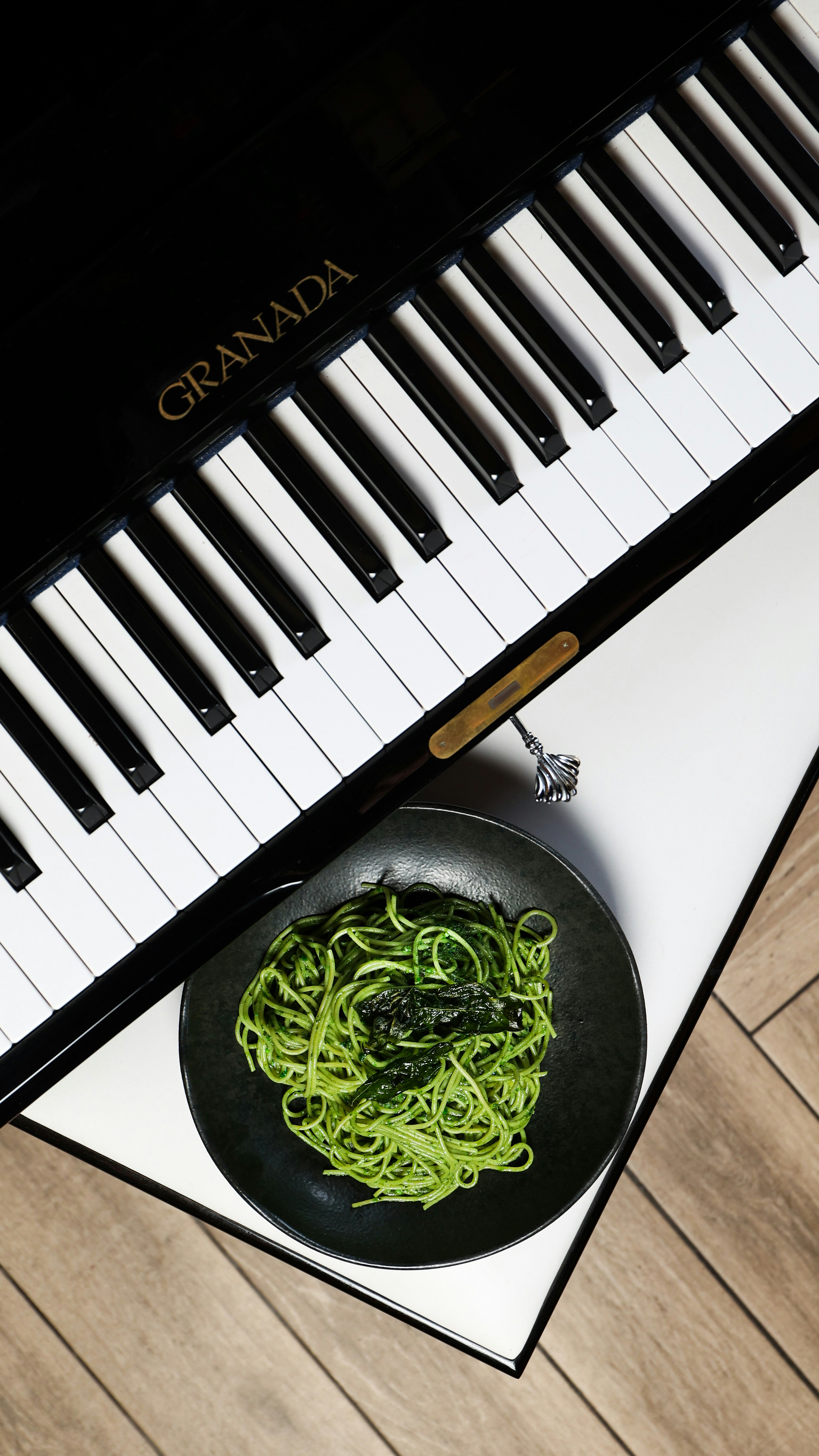 A bowl of noodles is next to a piano keyboard