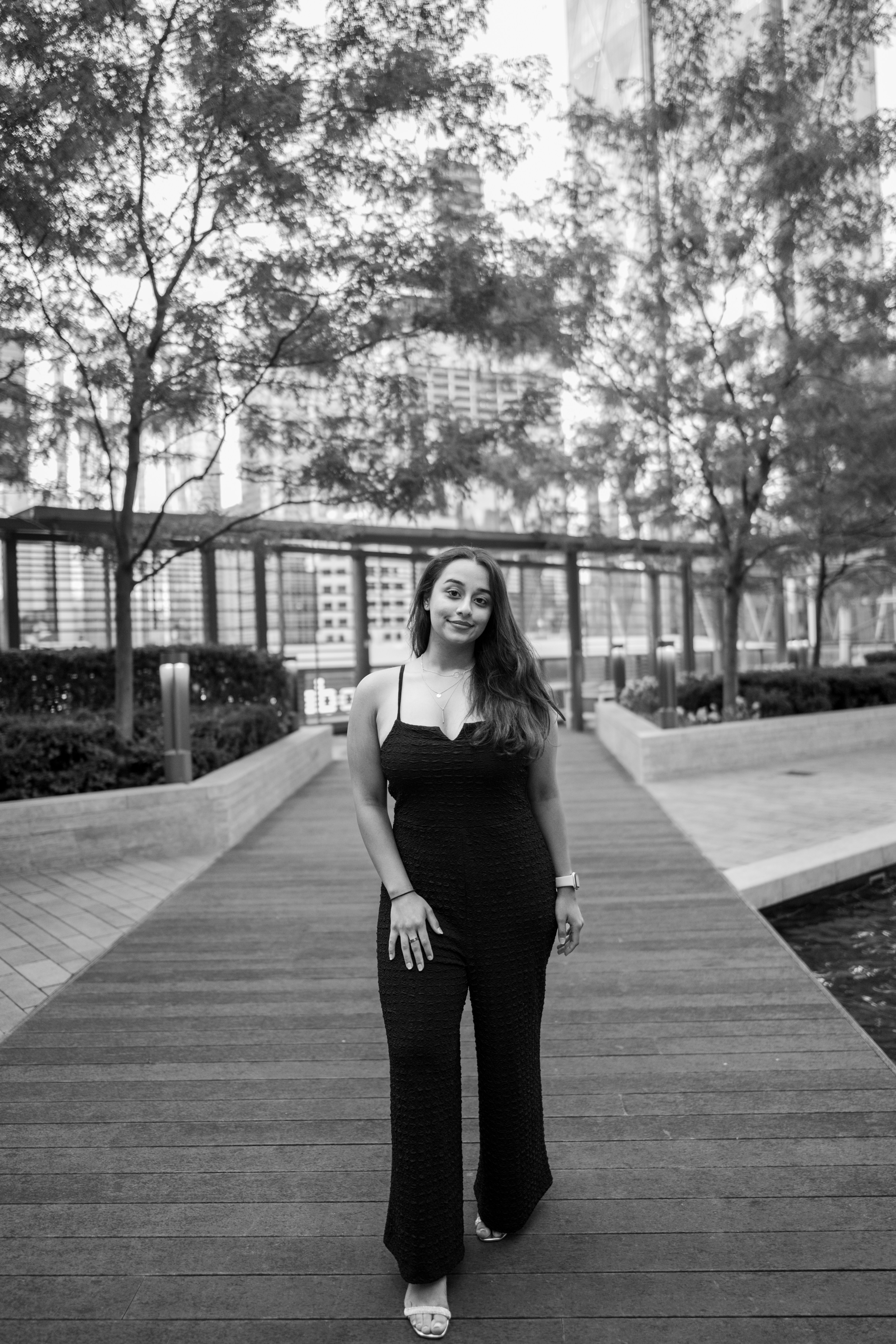 A woman in a black jumpsuit standing on a walkway