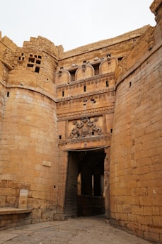 A stone building with a doorway and a clock on it