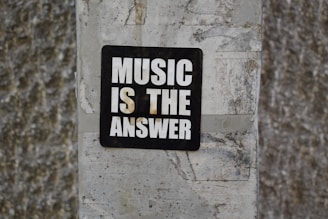 A sign on a wall that says music is the answer