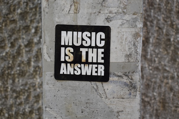 A sign on a wall that says music is the answer