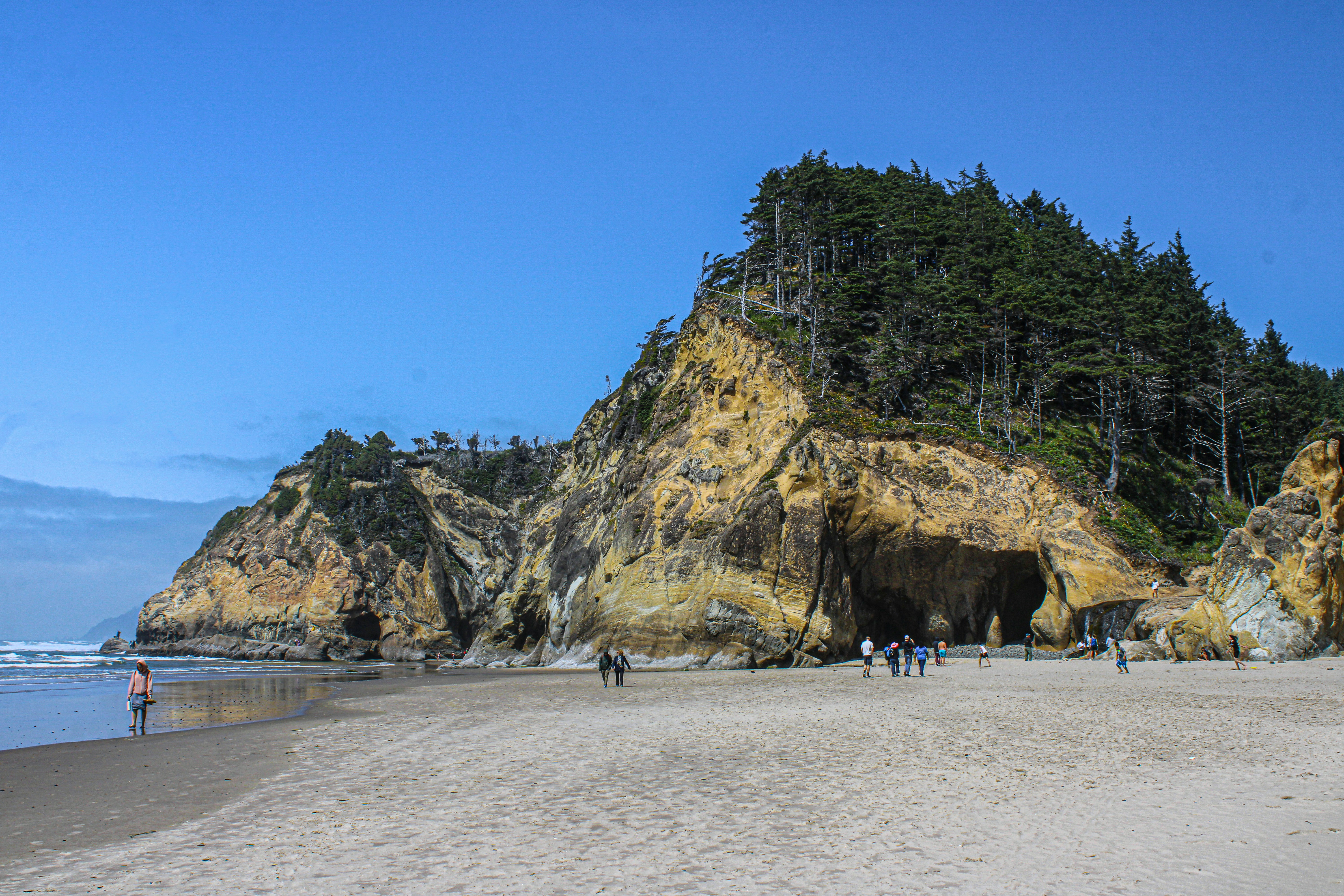 A group of people standing on top of a sandy beach