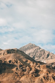A view of a mountain range with a few clouds in the sky