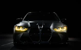 The front of a black sports car in the dark