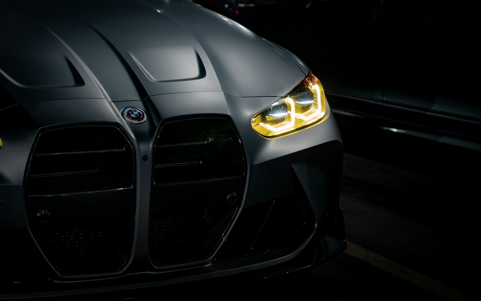 The front of a black sports car in the dark