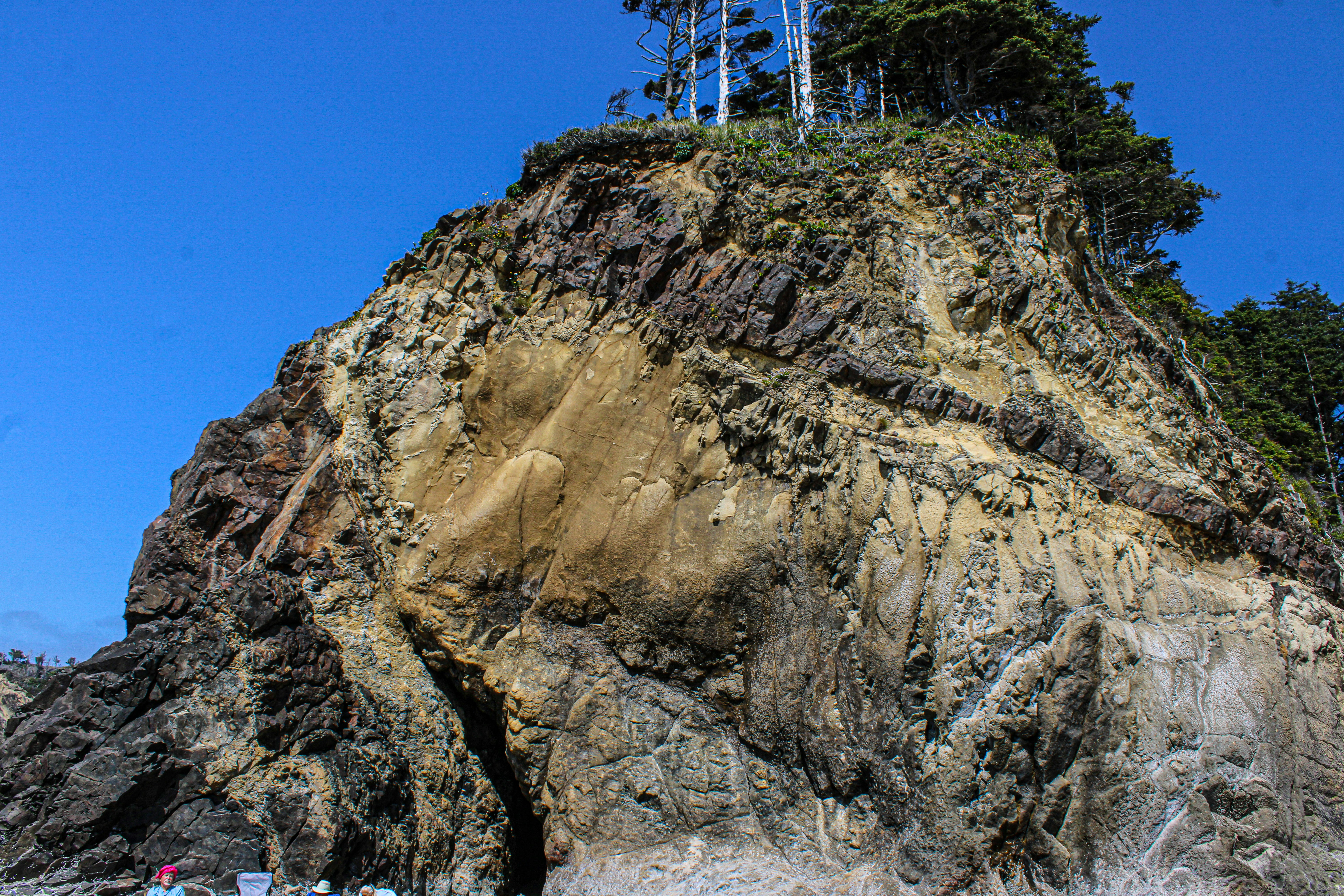 A group of people standing on top of a large rock