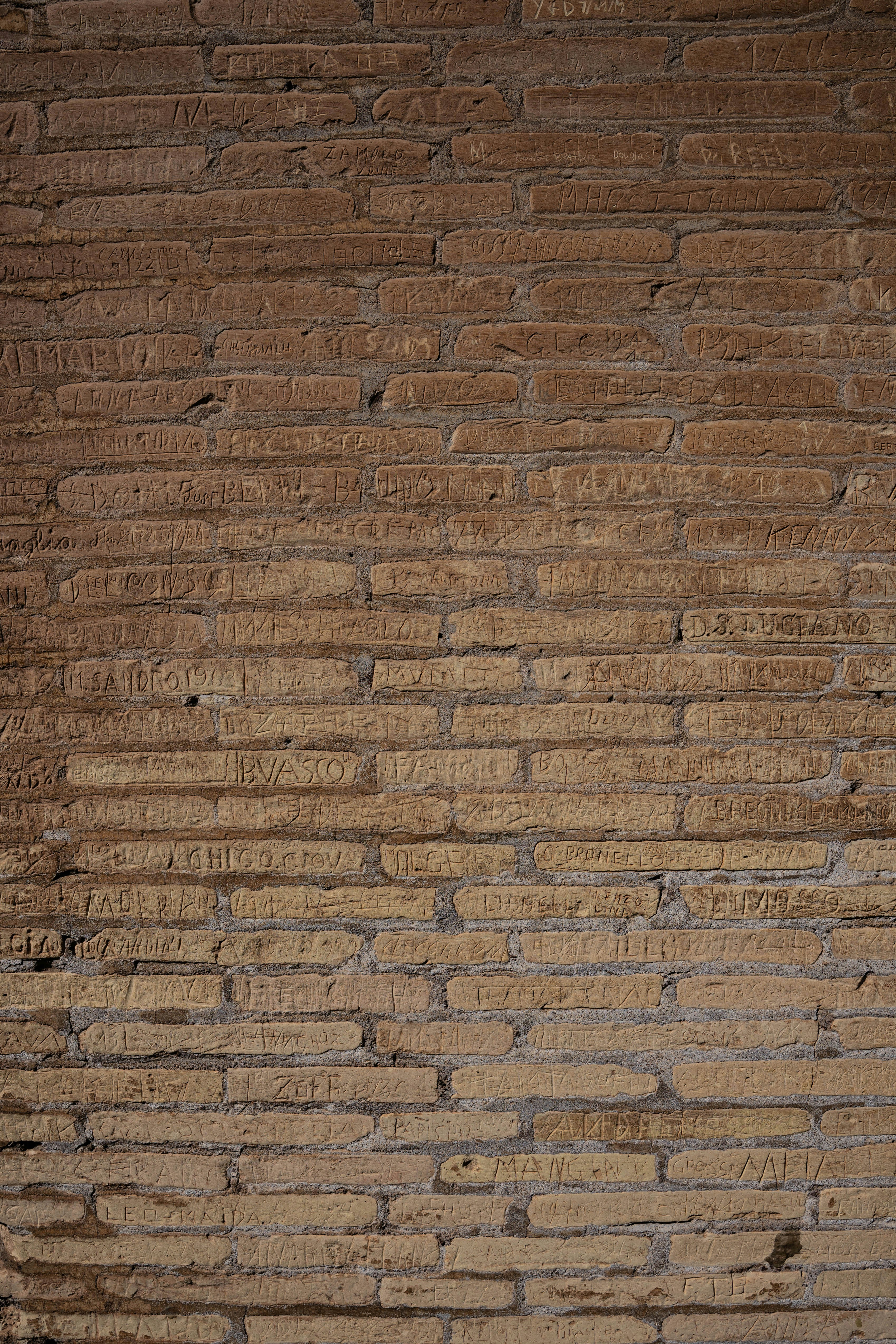 A skateboarder is doing a trick on a brick wall