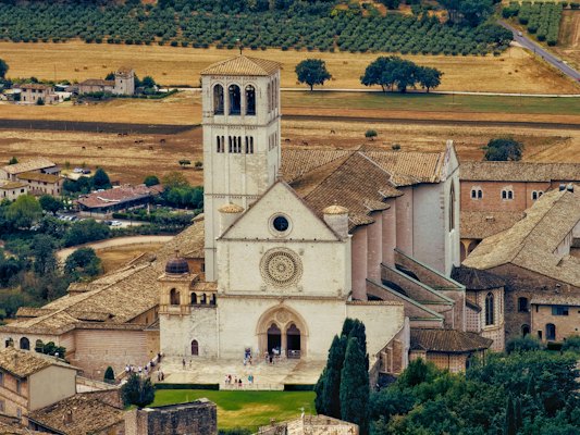 An aerial view of a small town with a church — Assisi, Italy