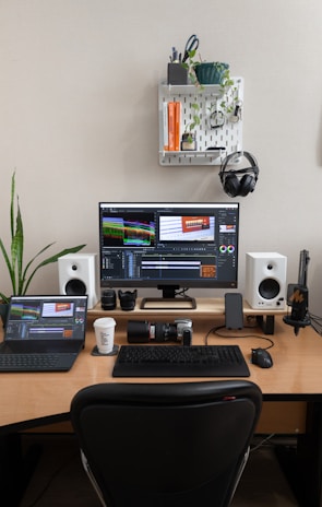 A desk with a computer and speakers on it